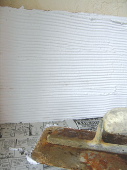 3. Use a notched trowel to apply tile mastic to the substrate on your wall. Use white mastic and grout so the glass really glistens.